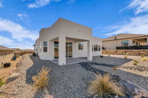 Rear view of house with a patio, central AC unit, and stucco siding