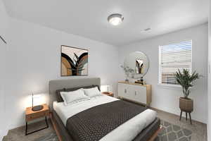 Carpeted bedroom with visible vents and baseboards