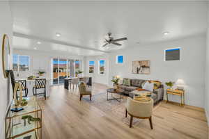 Living room featuring a ceiling fan, recessed lighting, light wood-style flooring, and baseboards