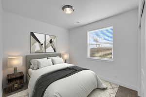 Bedroom featuring light colored carpet, visible vents, and baseboards