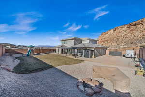 Back of house featuring a playground, a patio, a mountain view, and a yard