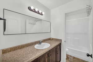 Full bathroom featuring vanity, shower / bathtub combination, and toilet