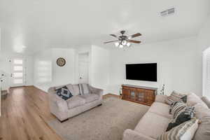 Living room featuring light hardwood / wood-style floors and ceiling fan