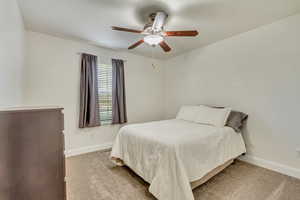 Carpeted bedroom featuring ceiling fan.