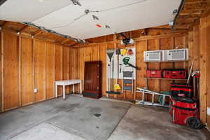 Garage featuring a garage door opener, and wood walls