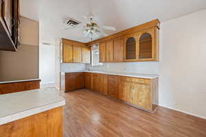 Kitchen with light hardwood / wood-style floors and ceiling fan