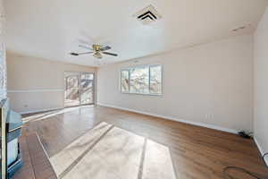 Unfurnished living room featuring ceiling fan and light hardwood / wood-style floors