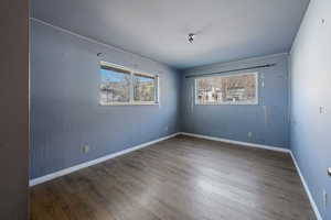 Empty room with dark hardwood / wood-style flooring