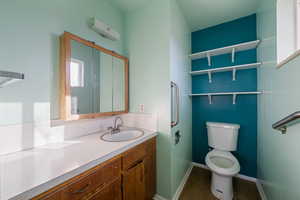 Bathroom with hardwood / wood-style floors, vanity, a wall mounted air conditioner, and toilet