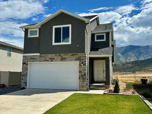 View of front of property with a garage and a mountain view