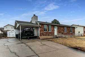 View of front of house with a carport and a storage unit