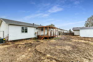 Rear view of house with a wooden deck and central air condition unit