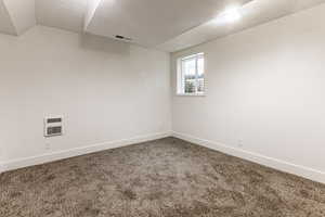 Spare room featuring carpet and a textured ceiling