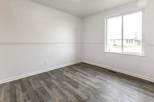 Empty room featuring dark wood-type flooring