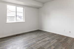 Empty room with dark wood-type flooring