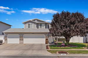 View of front of home with a garage and a front lawn