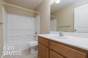 Full bathroom featuring vanity, bathtub / shower combination, tile patterned floors, and toilet