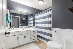 Bathroom with vanity, tile patterned floors, toilet, and a shower with shower curtain