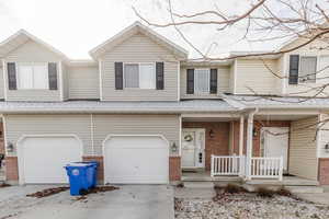 Multi unit property featuring a garage and covered porch