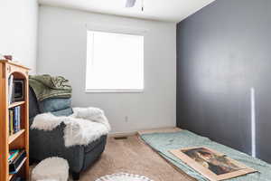 Living area featuring ceiling fan and carpet flooring