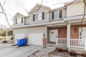 View of property with a garage and covered porch