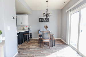 Dining room with hardwood / wood-style floors and an inviting chandelier