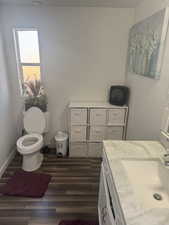 Bathroom featuring hardwood / wood-style flooring, vanity, and toilet