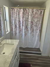 Bathroom with vanity, hardwood / wood-style floors, a textured ceiling, and a shower with shower curtain