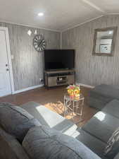 Living room with hardwood / wood-style flooring and lofted ceiling with beams