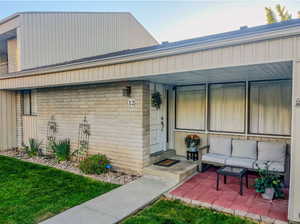 Entrance to property with a patio and a lawn