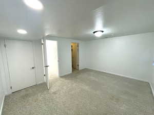 Interior space with light colored carpet and a textured ceiling