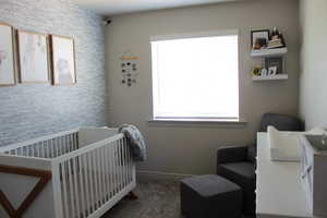 Carpeted bedroom with a nursery area