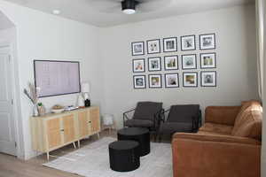 Living room featuring ceiling fan and light hardwood / wood-style flooring