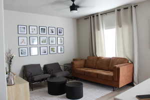 Living room with ceiling fan and light wood-type flooring