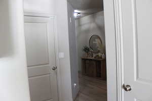 Hall with hardwood / wood-style flooring and a textured ceiling