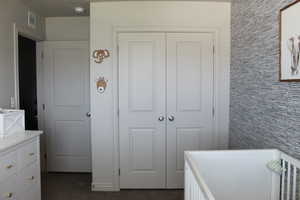 Bedroom with dark carpet and a closet