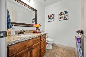 Bathroom with tile patterned flooring, vanity, and toilet