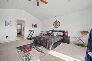 Carpeted bedroom featuring ceiling fan and lofted ceiling