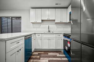 Kitchen featuring stainless steel appliances, dark hardwood / wood-style flooring, sink, and white cabinets