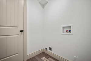 Clothes washing area with hookup for a washing machine, dark hardwood / wood-style floors, and hookup for an electric dryer