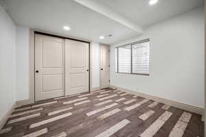 Unfurnished bedroom featuring a closet, dark hardwood / wood-style floors, and a textured ceiling