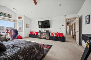 Bedroom featuring vaulted ceiling, light colored carpet, and ceiling fan