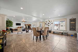 Dining area with a textured ceiling, ceiling fan, and light tile patterned flooring