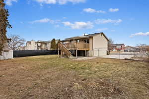 Back of house with a wooden deck and a yard