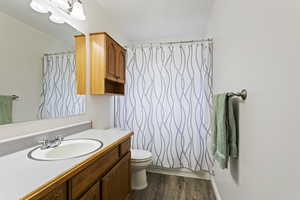 Full bathroom with vanity, toilet, LVP floors, and shower / bath combo