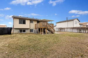 Rear view of property featuring a yard and a deck