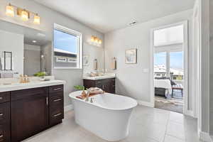 Master Bathroom with dual vanities, walk-in closet, separate shower and tub, and tile flooring