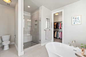 Master Bathroom with dual vanities, walk-in closet, separate shower and tub, and tile flooring