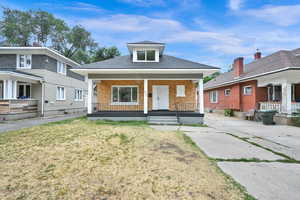 Bungalow featuring a front yard and covered porch