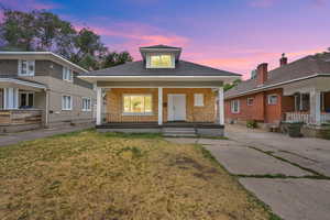 Bungalow-style house featuring a lawn and covered porch